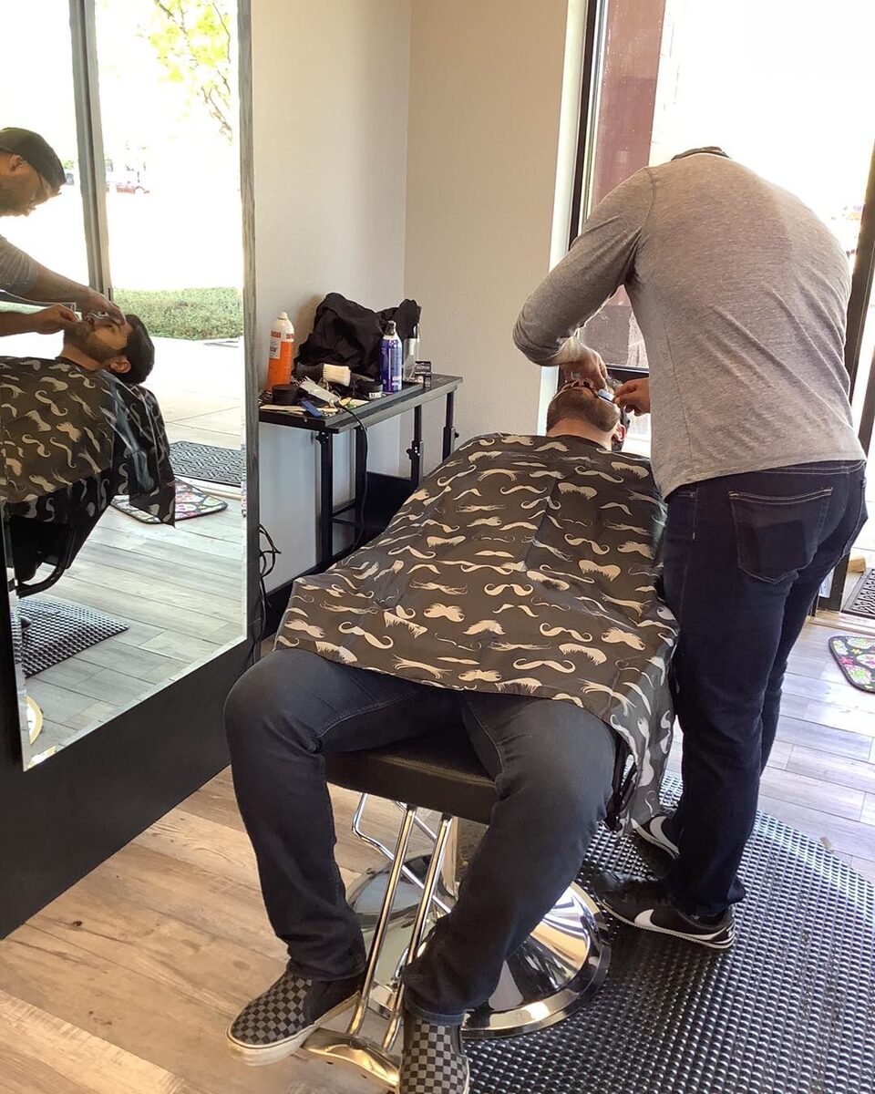 A barber at work inside El Mustachio Barbershop